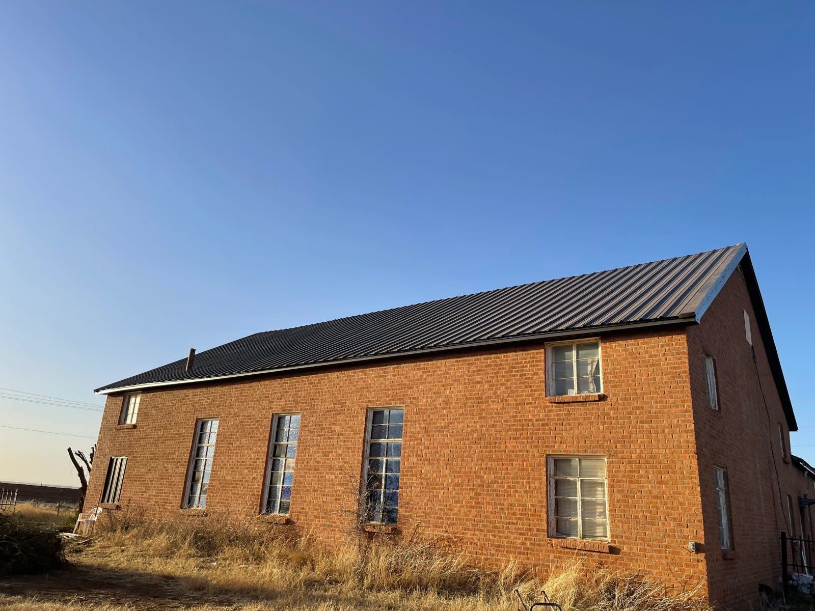 Dark metal roof on a two-story brick house